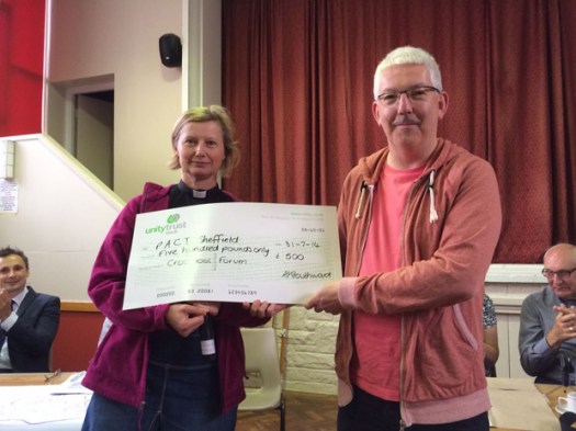Robin from PACT receives the cheque from festival chair Frances Eccleston